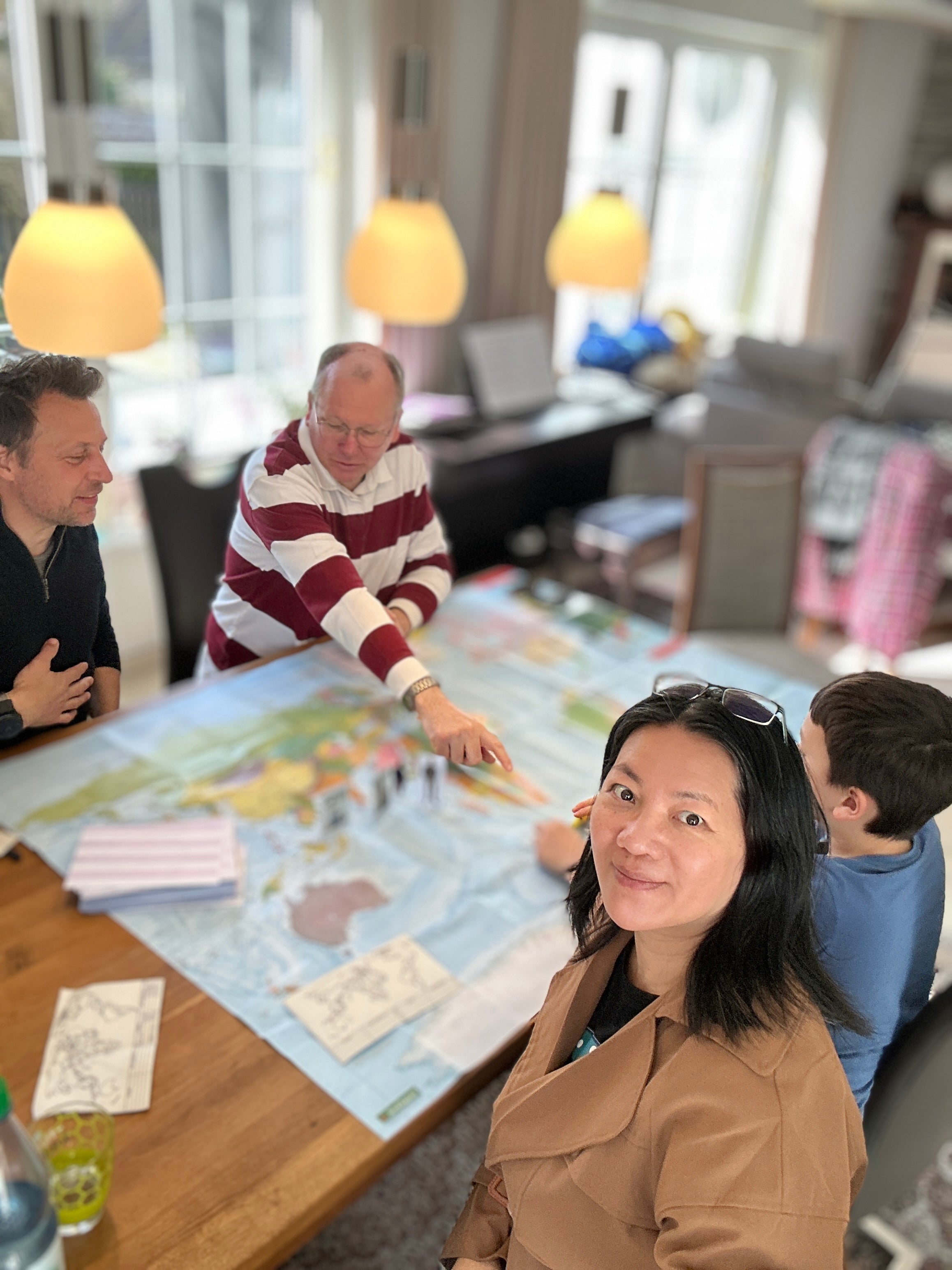 Familie spielt zusammen WELTKARTE Geografie-Brettspiel